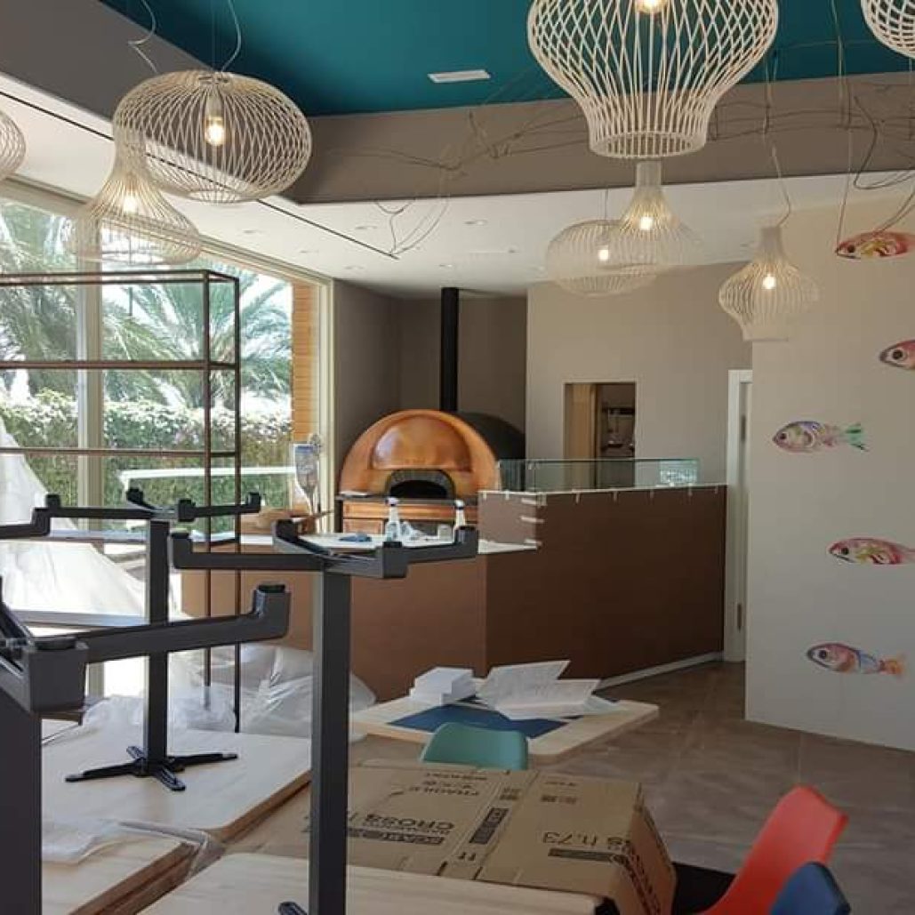 Decorazioni interne di un ristorante con murales colorati e lampadari di design.