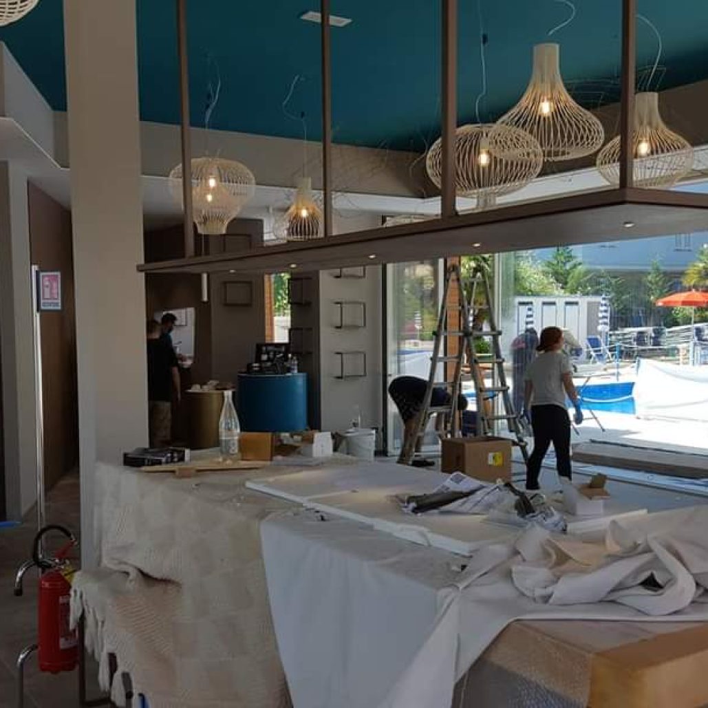 Interno di un ristorante con forno a legna e vetrate luminose.
