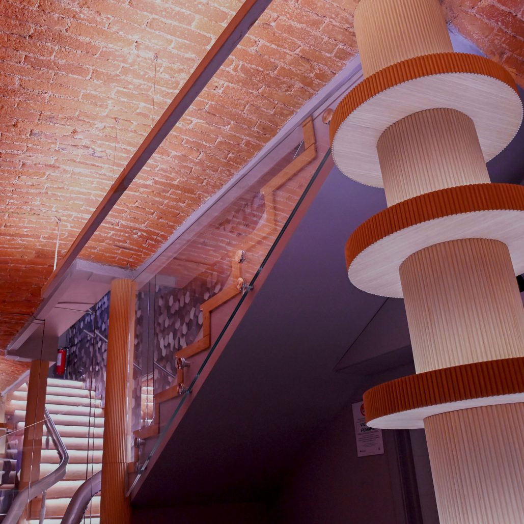 Colonna porta bottiglie in legno con illuminazione integrata, ideale per arredamento su misura.
