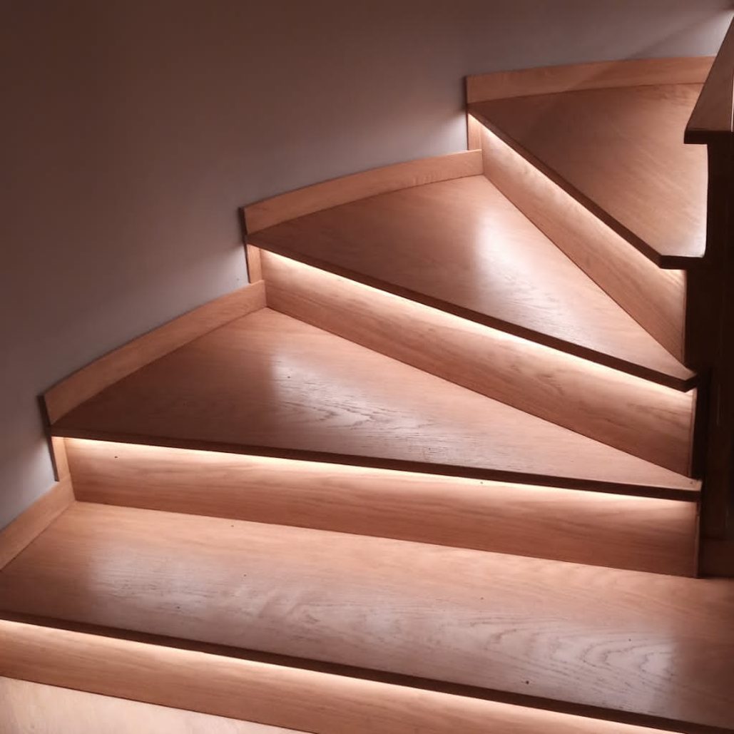 Dettaglio della scala in legno con illuminazione a LED integrata.